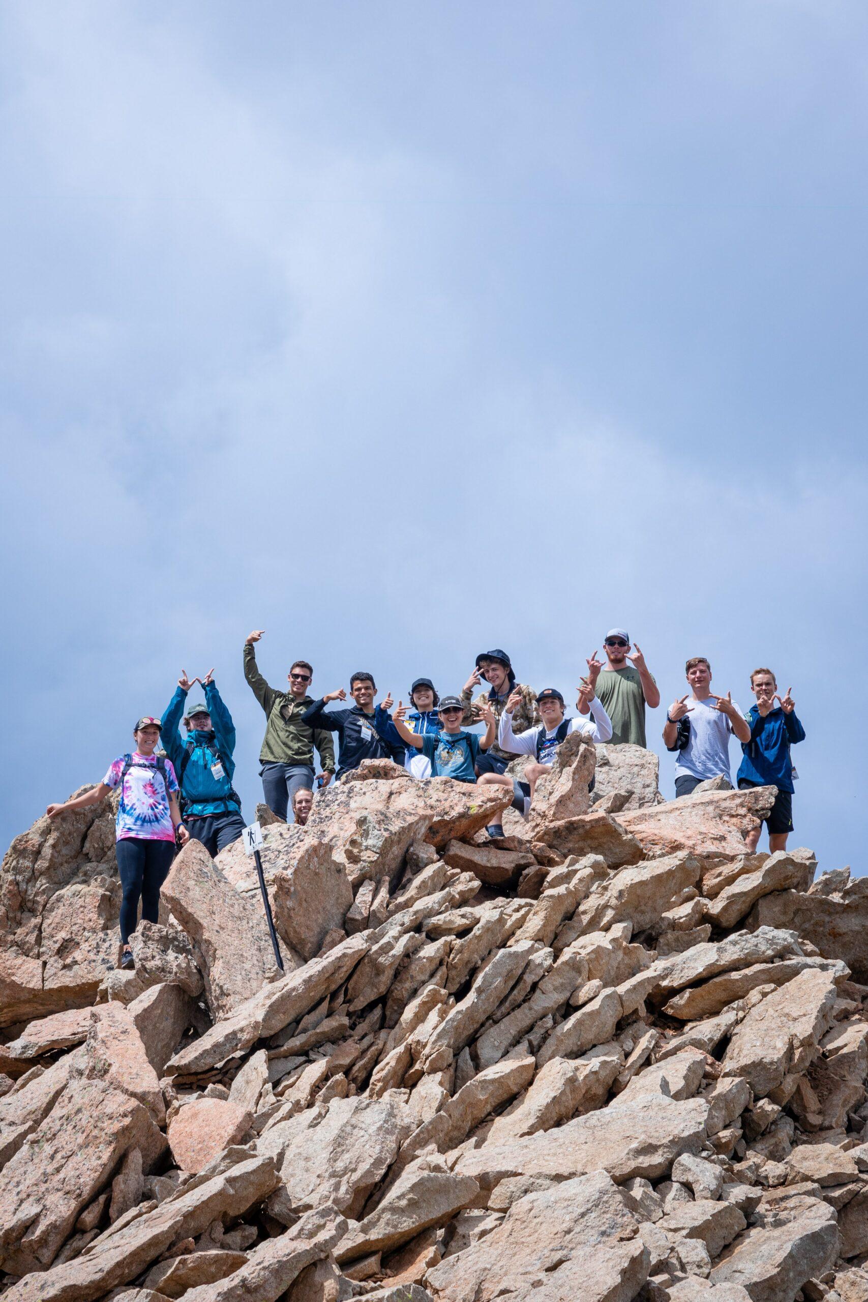 Students pose for a photo on top of Mount Crested Butte in the summer